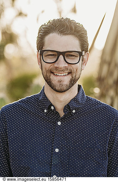 Headshot portrait of mid adult male with glasses  outside