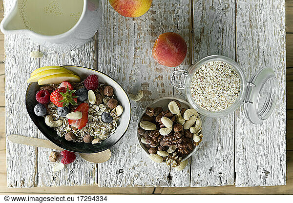 Healthy breakfast: muesli  fruit  milk on rustic wooden tray