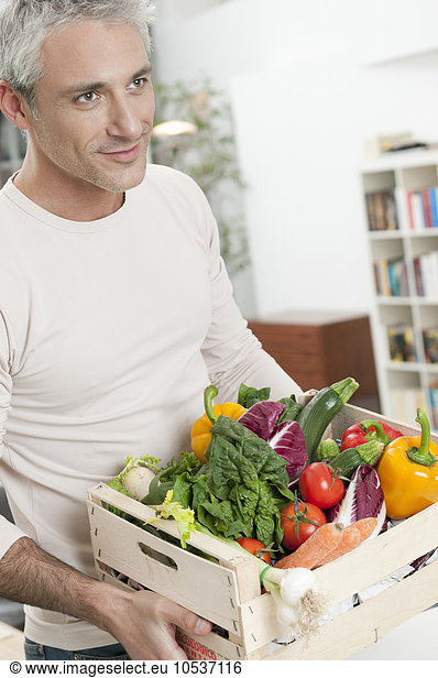 Healthy man with vegetables crate