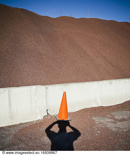 Heap of sand or gravel and shadow of a person