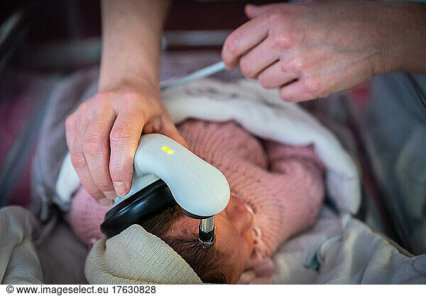 Hearing test on an infant by a nurse in a hospital center.