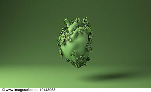 Heart covered with green plants against green background