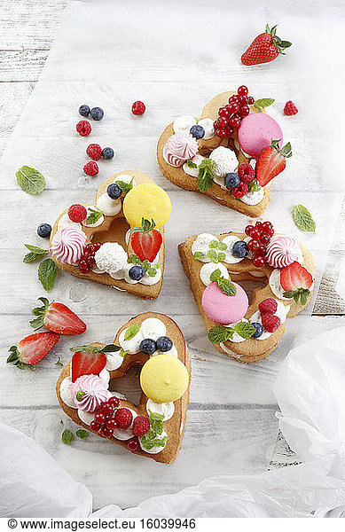 Heart-shaped cakes with meringue  fruit and macaroons