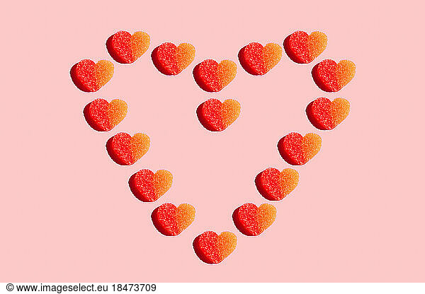 Heart shaped candy flat laid against red background
