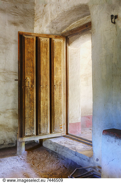 Heavy wooden door in adobe building at Mission La Purisima State Historic Park  Lompoc  California  Founded in 1787  the eleventh mission of the twenty-one Spanish Missions established in California