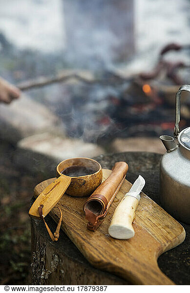 Heißer Tee in der Schöpfkelle neben dem Messer auf dem Schneidebrett