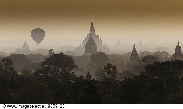 Heissluftballon schwebt durch den dunstigen Himmel von Bagan  Myanmar