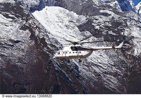 Helicopter flying against mountain