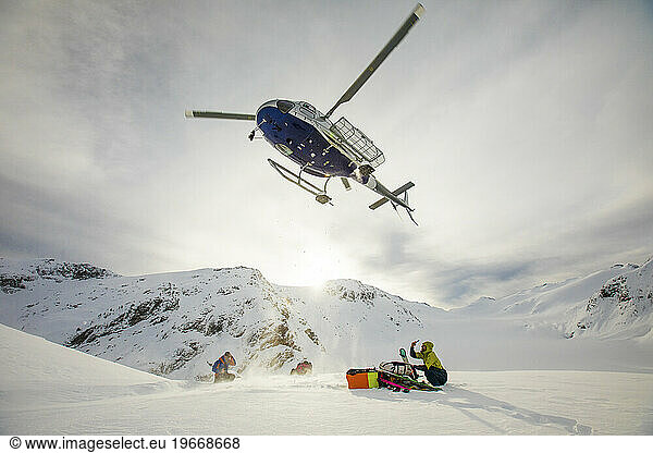 Helicopter flying in mid-air above two passengers after drop off