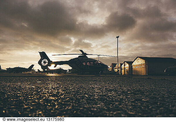 Helicopter on landing place during sunset