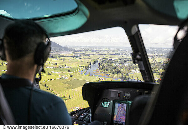 Helicopter pilot looking out at farmland in the Fraser Valley.