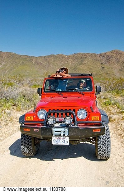 hellhäutiger Mann und Frau im Jeep mit Video-Kamera. Joshua Tree Park. Kalifornien. USA.