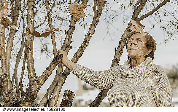 Herbstblätter fallen auf ältere Frau