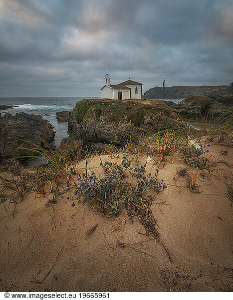 Hermitage on an islet in the Galician coast during sunset