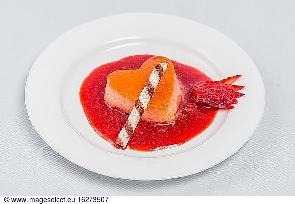 Herzförmiger Pudding mit Erdbeersauce und Waffel. Rezept für ein Dessert zum Valentinstag.