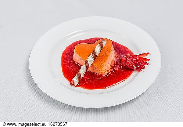 Herzförmiger Pudding mit Erdbeersauce und Waffel. Rezept für ein Dessert zum Valentinstag.