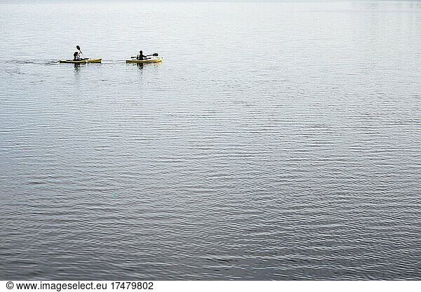 Heterosexual couple kayaking on lake during weekend