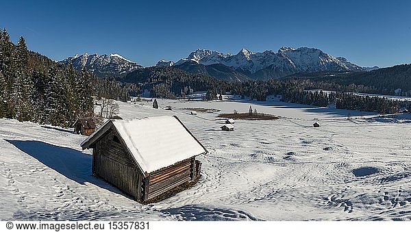 Heuhaufen in schneebedeckter Landschaft  zugefrorener Geroldsee im Winter vor Karwendelgebirge  Mittenwald  Oberbayern  Bayern  Deutschland  Europa