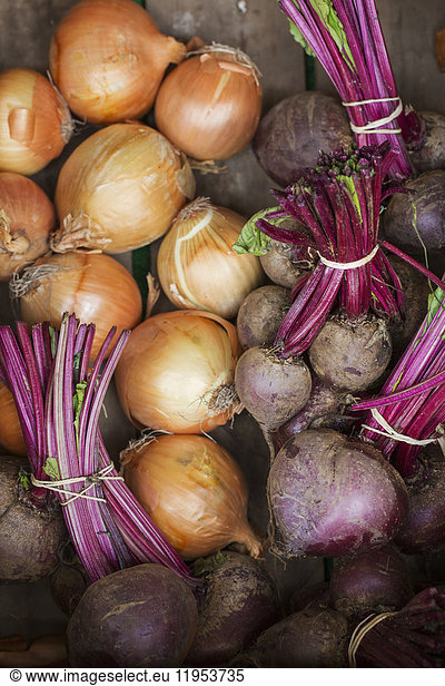High angle close up of brown onions and fresh beetroot.