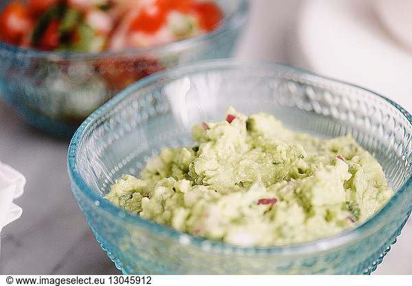 High angle close-up of green chutney in bowl on table
