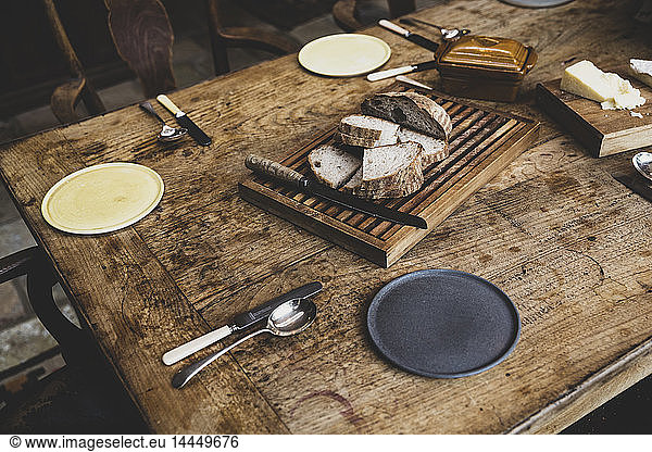 High angle close up of plates  cutlery and bread on a vintage wooden table.