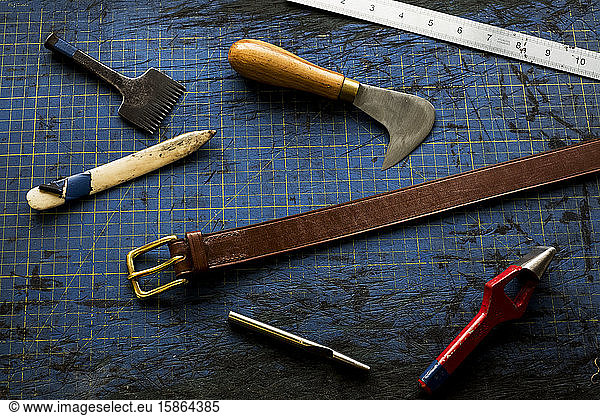 High angle close up of selection of saddle making hand tools.