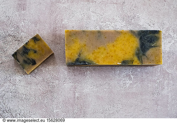 High angle close up of yellow and black homemade bar of soap.