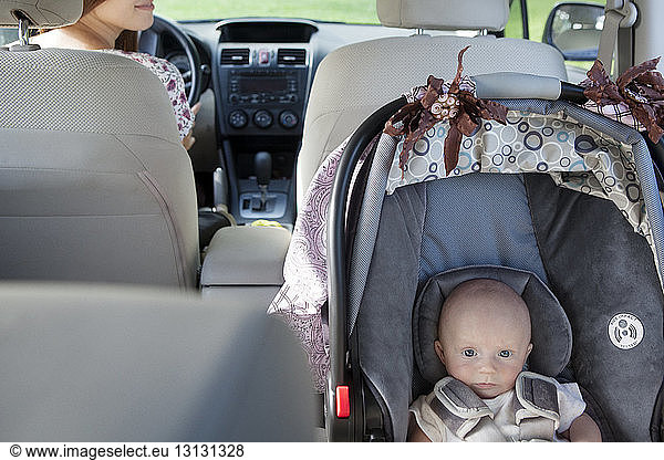 High angle portrait of toddler sitting in car seat