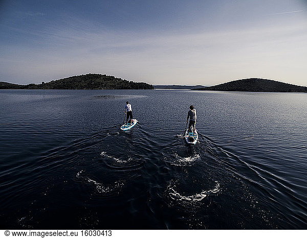 High angle shot of two people on paddleboards.
