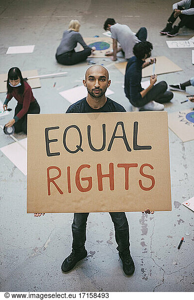 High angle view of bald man with equal rights sign standing in building