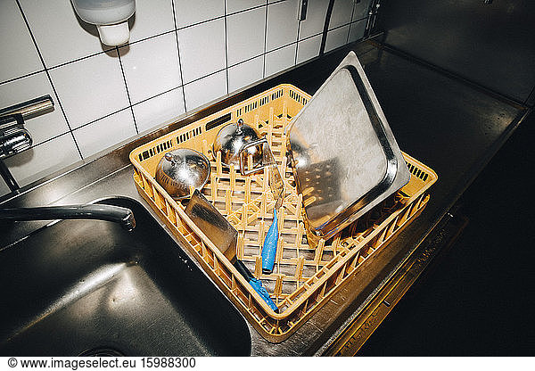 High angle view of basket with kitchen utensils on kitchen counter in cafe