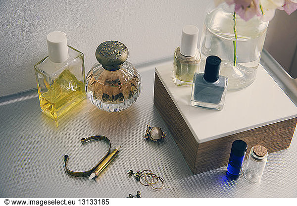 High angle view of beauty products with jewelry on table