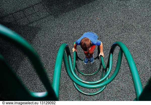 High angle view of boy playing on outdoor play equipment