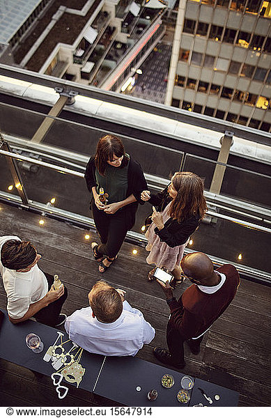High angle view of business colleagues talking while enjoying office party after work