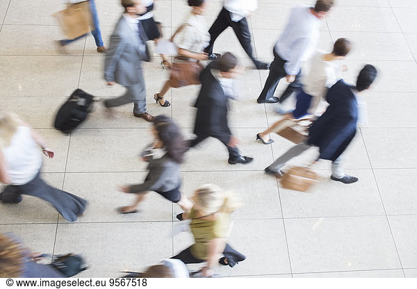 High angle view of business people walking in office on tiled floor