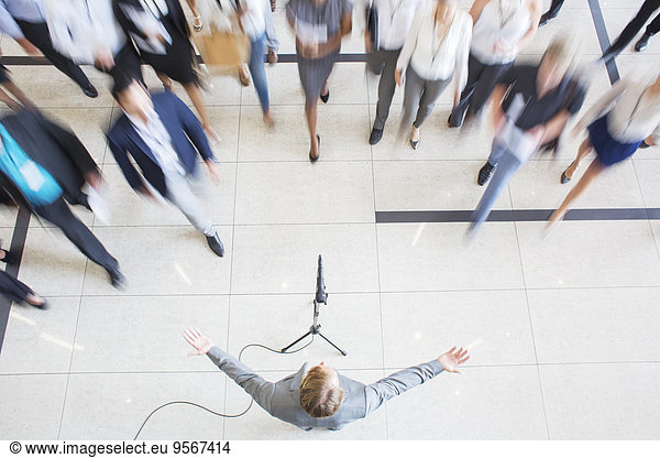 High angle view of business people walking towards colleague giving speech