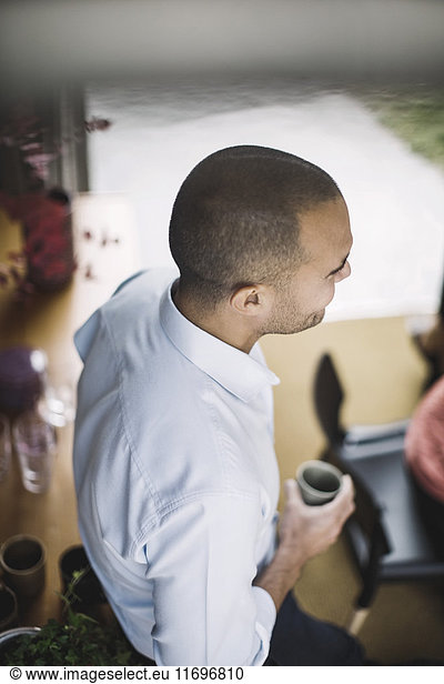 High angle view of businessman holding coffee cup in portable office truck