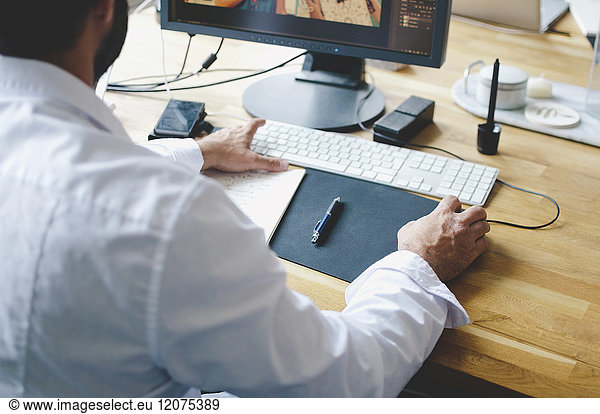 High angle view of businessman using computer at desk in creative office