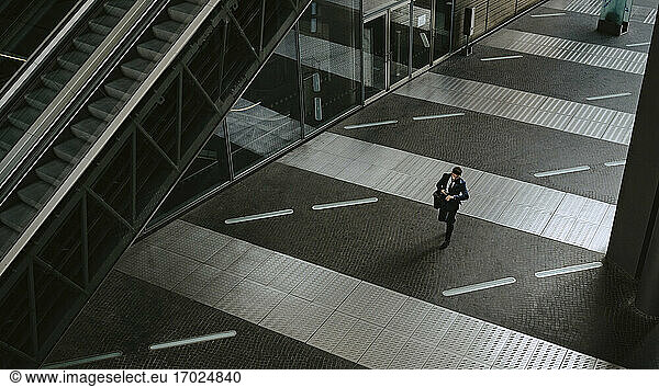 High angle view of businessman walking on footpath