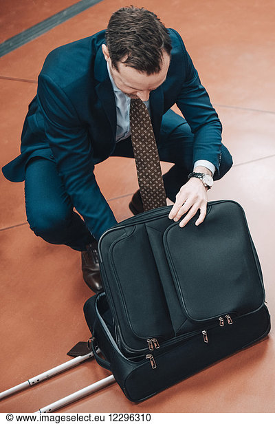 High angle view of businessman with suitcase at subway station