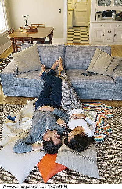 High angle view of couple relaxing on carpet at home