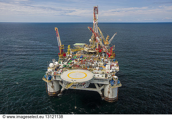 High angle view of cranes on oil exploration platform amidst sea