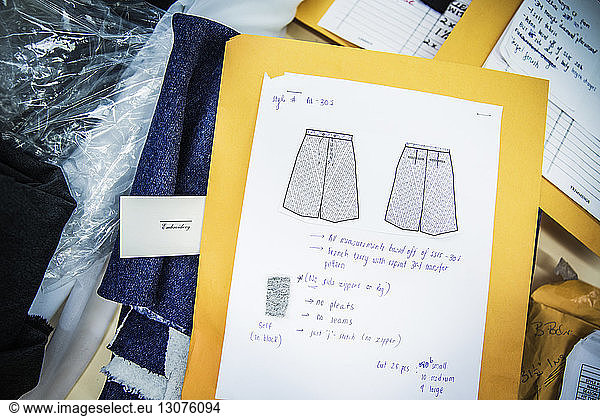 High angle view of drawing and text on document at table in design studio