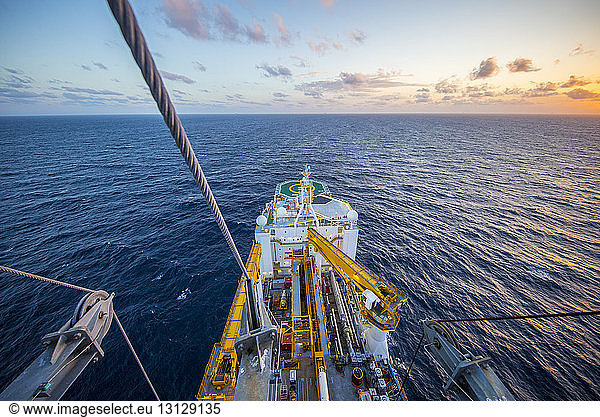 High angle view of drill ship in sea against sky during sunset