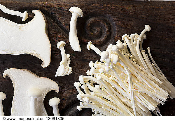 High angle view of edible mushrooms on wooden table