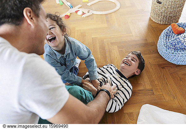 High angle view of father playing with children at home