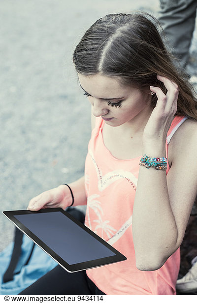High angle view of female high school student using digital tablet outdoors