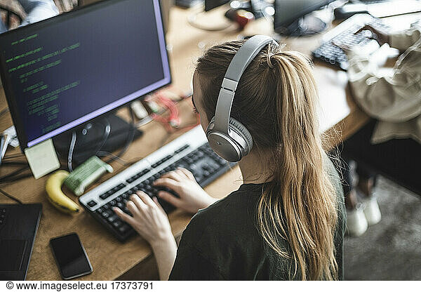 High angle view of female programmer working at startup company