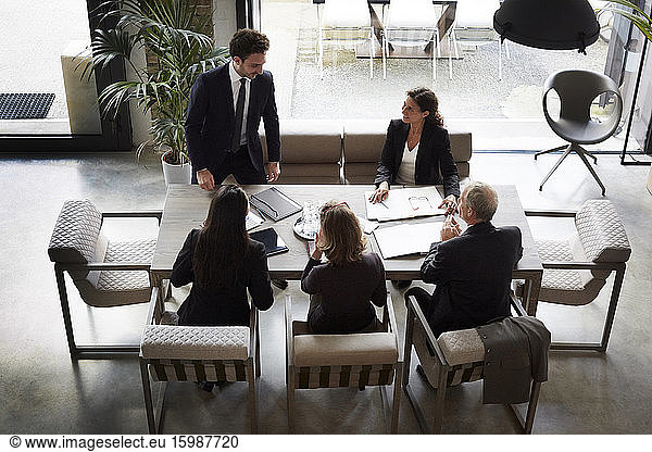 High angle view of financial advisors with businessman and businesswoman planning at office during meeting