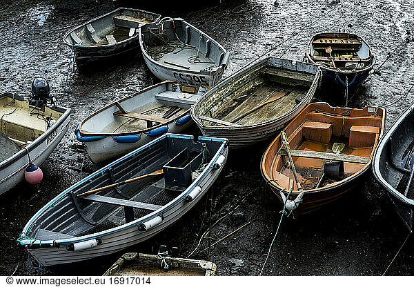 High angle view of fishing boats moored in harbour at low tide.